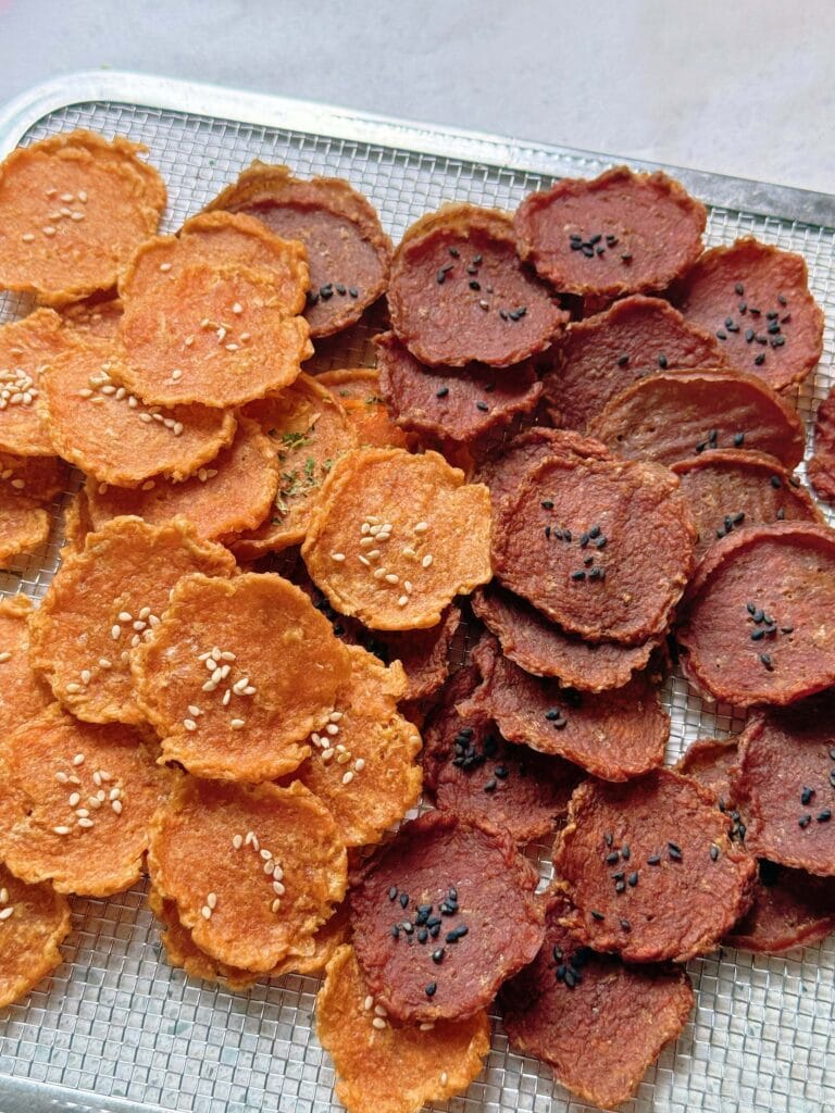 Pet dried meat slices produced by fresh meat dried slice production line, featuring chicken and beef flavors with black and white sesame seeds, low-temperature heat pump drying preserves natural meat aroma.